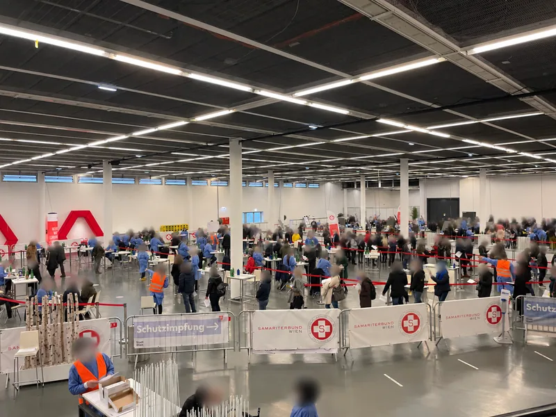 An overview of the Austria Center vaccination centre with workstations, visitors and waiting areas