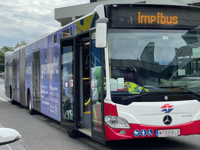 A bus equipped for mobile vaccinations with an illuminated Impfbus sign
