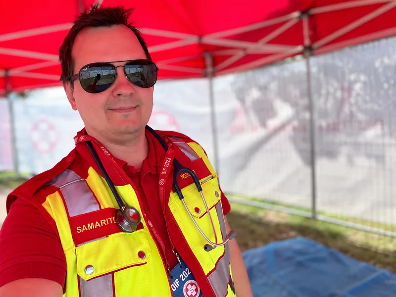 Helmut Steinbrecher in emergency physician uniform under a red event canopy