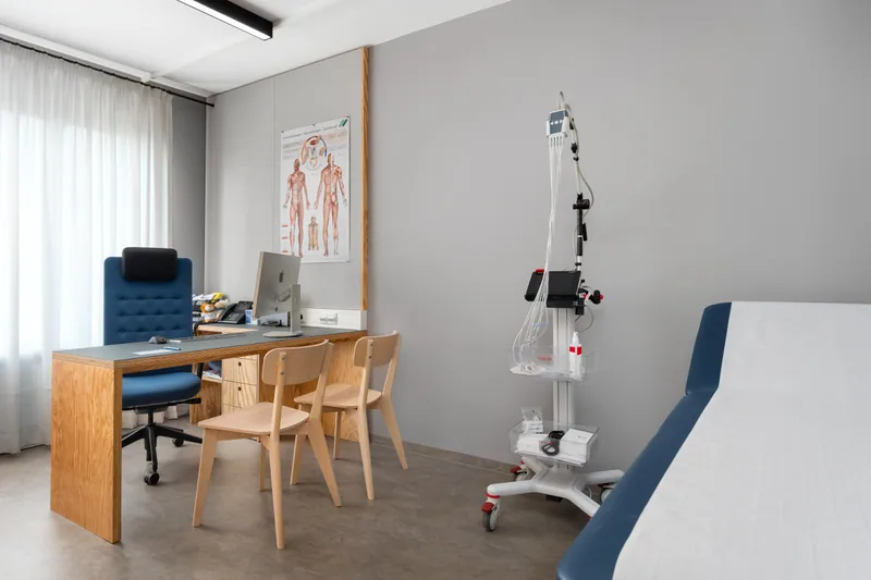 A consultation room at Praxis 23 with an examination couch and the doctor’s desk